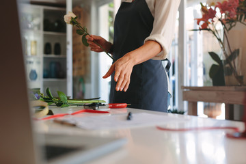 Florist making bouquet with flowers on counter