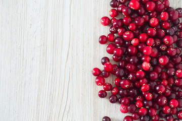 fresh cranberries on white wooden surface
