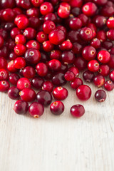 fresh cranberries on white wooden surface