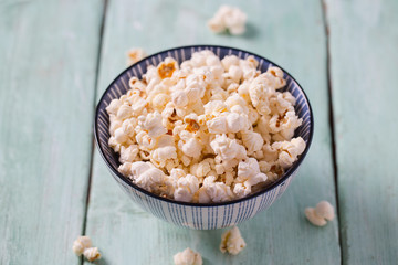 salty popcorn on turquoise wooden surface