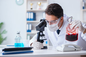 Doctor working with blood samples in hospital clinic lab