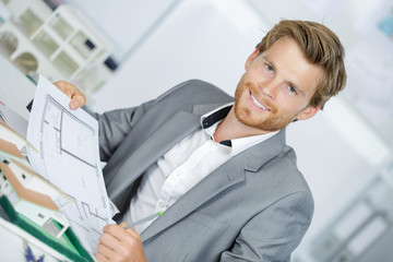 happy smiling engineer working on plane of house