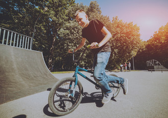 Bmx rider performing tricks at skatepark.