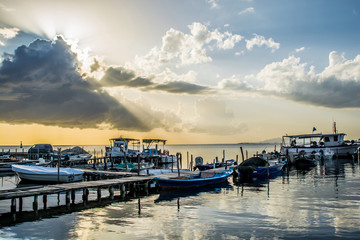 Fototapeta na wymiar The pier of fishing boats in Tourlida, Mesologi at sunset on a colorful cloudy day, Greece