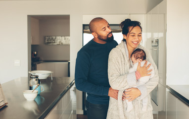Obraz premium Couple with their little baby boy in kitchen
