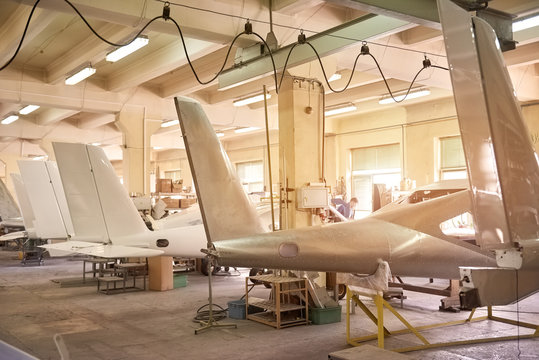 Inside aircraft workshop. Tails of airplanes. Aviation industry development.