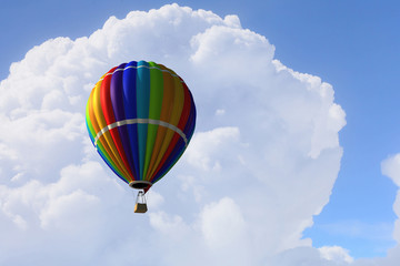 Aerostat floating in day sky. Mixed media