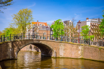 Naklejka premium Traditional old buildings and and boats in Amsterdam, Netherlands. Canals of Amsterdam.