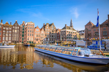 Traditional old buildings and and boats in Amsterdam, Netherlands. Canals of Amsterdam.