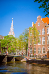 Naklejka premium Traditional old buildings and and boats in Amsterdam, Netherlands. Canals of Amsterdam.