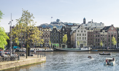 Naklejka premium Traditional old buildings and and boats in Amsterdam, Netherlands. Canals of Amsterdam.