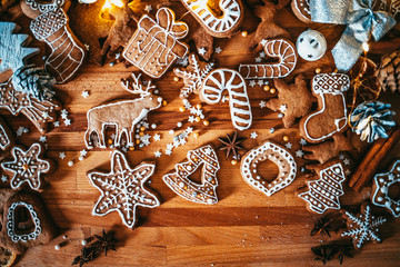Freshly baked and homemade gingerbread cookies and food decorations on wooden table, flat lay view from above. Christmas handmade bakery. Family festive culinary and New Year traditions concept.
