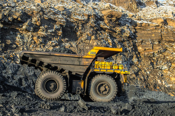 Fototapeta na wymiar Big yellow dump truck and excavator in the coal mine 