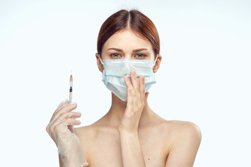 young woman in a medical mask holds a syringe in her hand, plastic surgery, beauty, portrait, light background