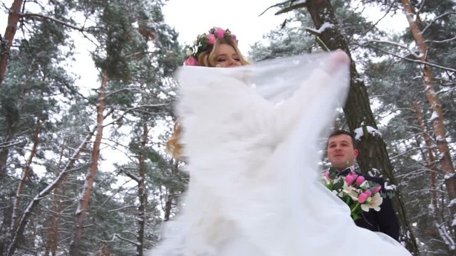 Woman in long dress and silver shoes walking at winter sunny day in slow motion