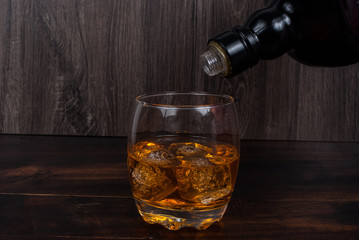 whisky on the rock on wood and wood background