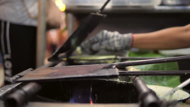Asian Woman Cooking Green Pancakes Dessert Roti Saimai at Street Food Nigth Market in Bangkok, Thailand. 4K.
