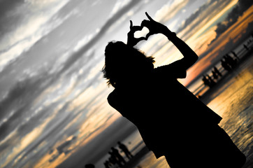 Girl Doing Heart Shape in Sunset