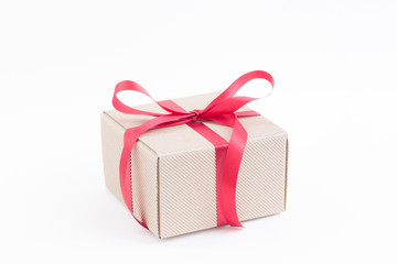 Obraz premium Brown gift box with red ribbon on white background