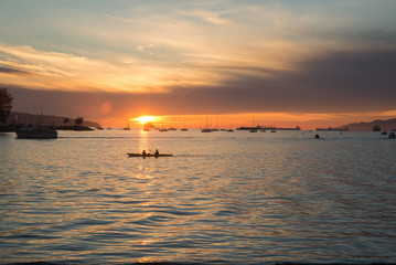Fototapeta na wymiar Two people kayaking during the sunset on English bay Vancouver
