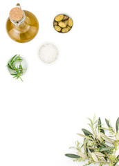 Glass bottle of premium virgin olive oil, sea salt, rosemary and some olives with olive branch isolated on a white background. Top view
