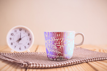 Coffee cup and clock on wood table. vintage color effected