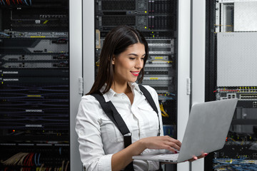 Portrait of technician working on laptop in server room