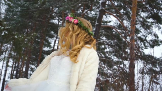 Woman in long dress and silver shoes walking at winter sunny day in slow motion