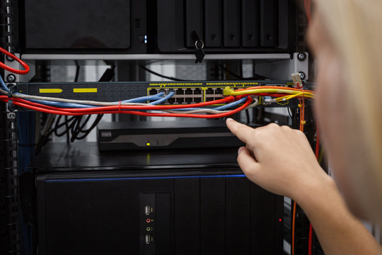 Close-up Of Engineers hand checking Server In Data Center