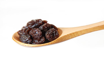 Black raisins on a wood spoon