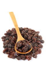 Black raisins on a wood spoon