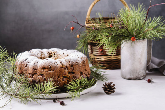 Traditional homemade christmas cake with nuts and dried fruit on light grey background. Christmas decoration. Selective focus 