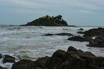 Landscape rocks on the beach, sea and little island. Vung Tau, Vietnam.