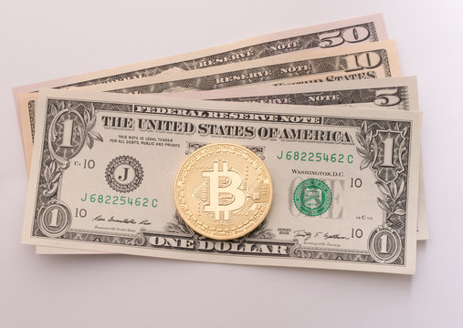 Golden bitcoin on dollar bills close up shot