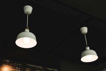 Hanging modern ceiling lights, on black ceiling. Selective focus