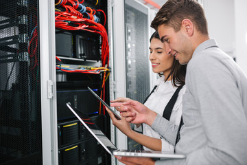 Fototapeta premium Team of technicians working together on servers at the data centre