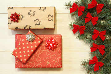 Fototapeta na wymiar New Year / Christmas gifts in package, tree with red bows on the wooden background template