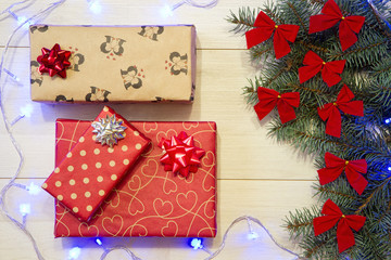 New Year / Christmas gifts in package, tree with red bows and blue garland on the wooden background template