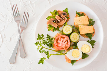 Tasty sandwiches on a plate and forks on a table. Top view