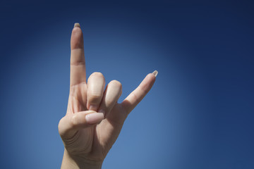 Love you sign on blue sky background, hand language