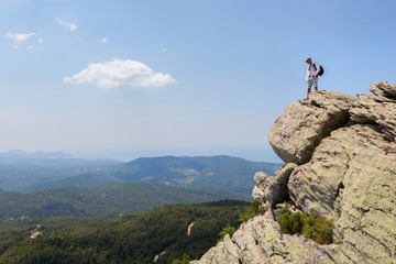 Tourist man on top of high mountains of peninsula Sithonia