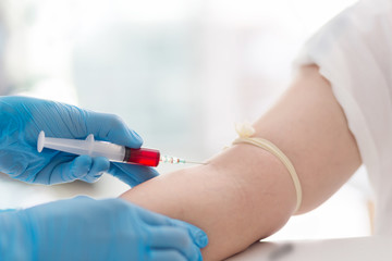 Close up Hand of nurse, doctor or technician in blue gloves taking blood sample from a patient in...