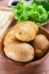 Pile of Raw Potatoes on wooden Bowl