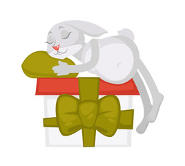 Bunny sleeps on huge gift box with ribbon and bow