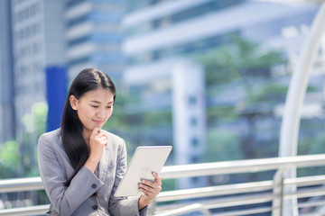 businesswoman look at his tablet in outdoor of office.