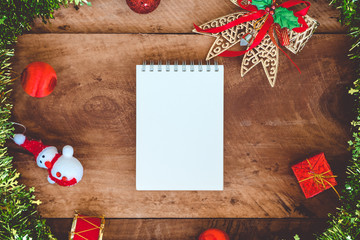 Top view mockup image of white blank notebook with christmas decorations on wooden background