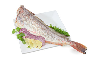 Uncooked red cod, sliced lemon and red onion, herbs