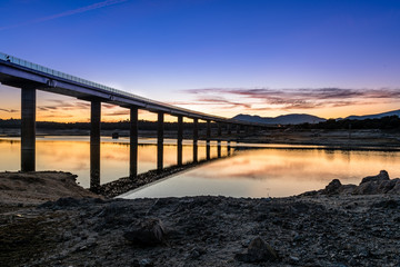 Fototapeta na wymiar Silhouette Of Bridge Over lage at sunset