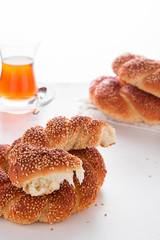 Turkish bagel, simit, and traditional tea on a table.