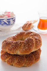 Turkish bagel, simit, and traditional tea on a table.